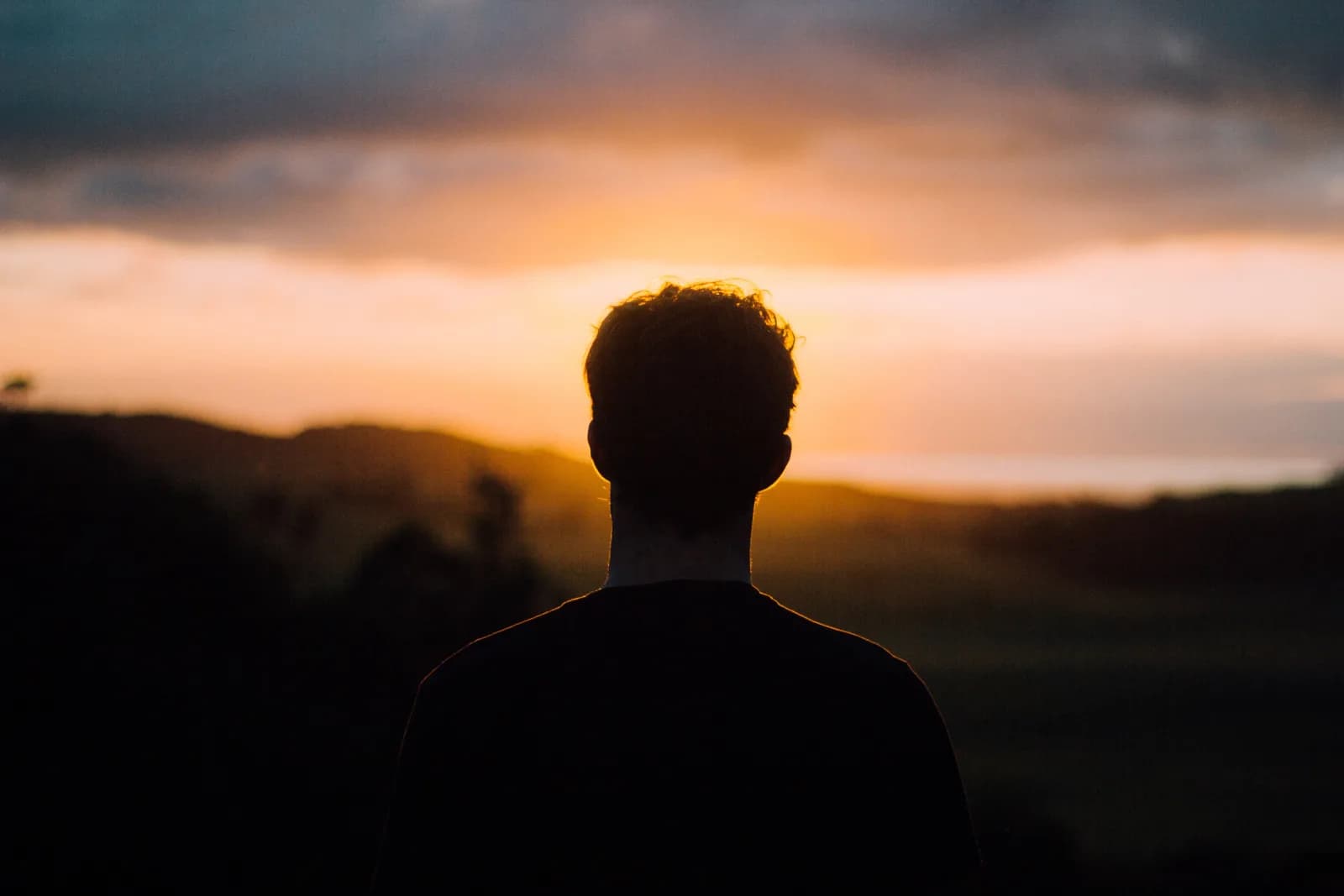 A man looking toward the sunrise